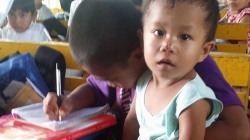 Tras la muerte de su madre niño asiste a clases con su hermano de dos años en brazos
